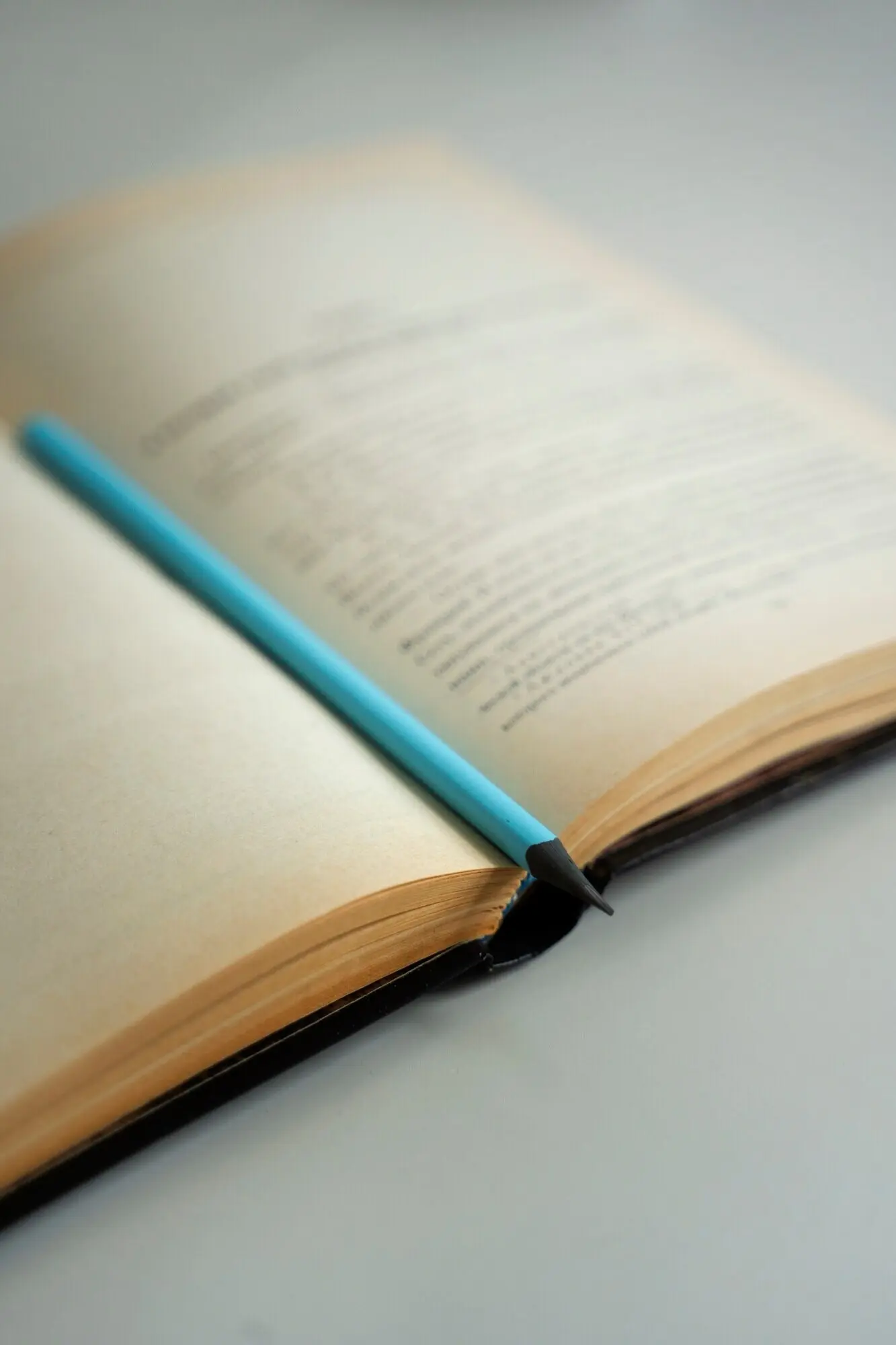 Книга с карандашом на столе, вид сверху